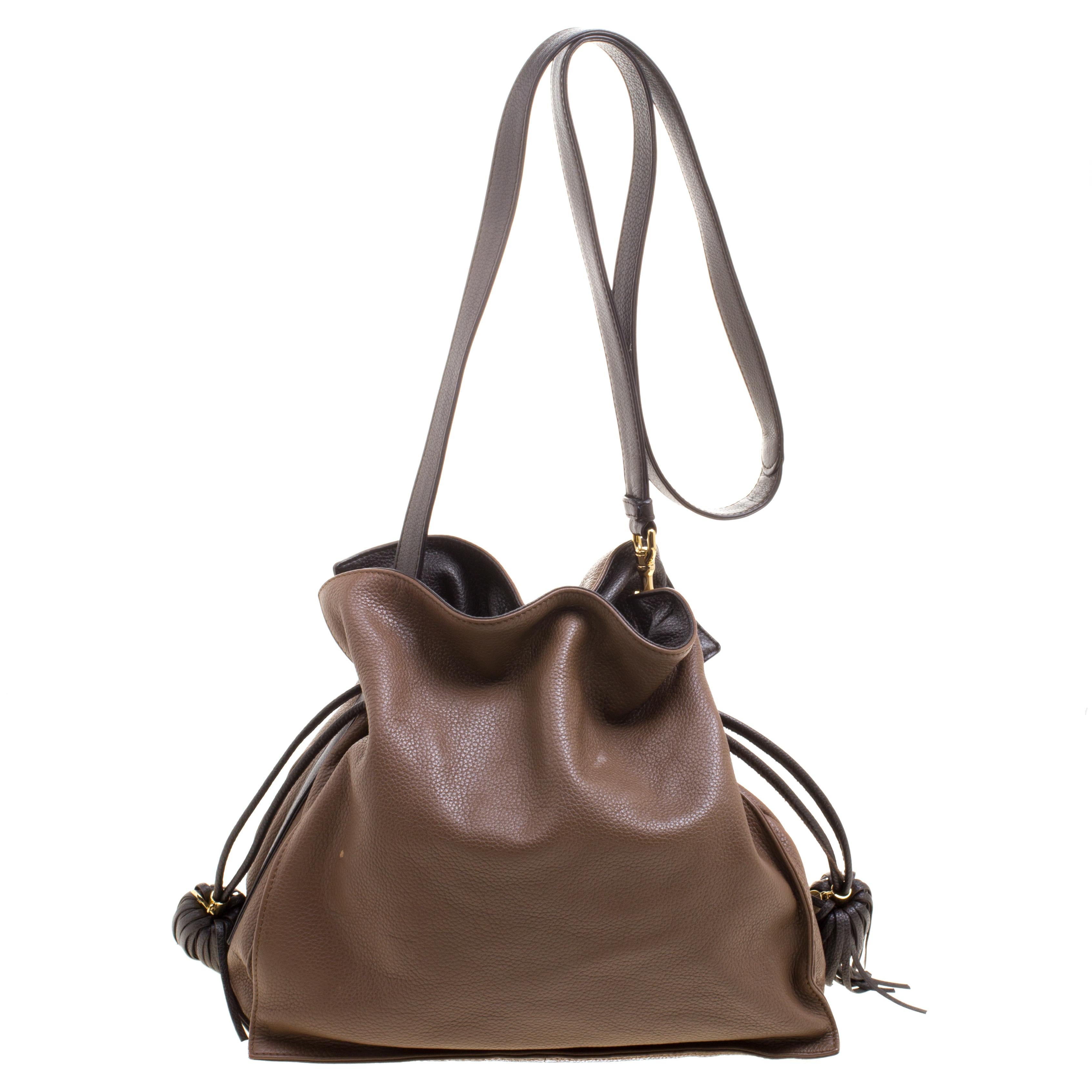 Loewe's shoulder bag is crafted from brown leather and comes with a removable shoulder strap. The drawstring closure with tassel detail opens to a fabric lined interior that has a slip pocket and a zip pocket. This creation is definitely