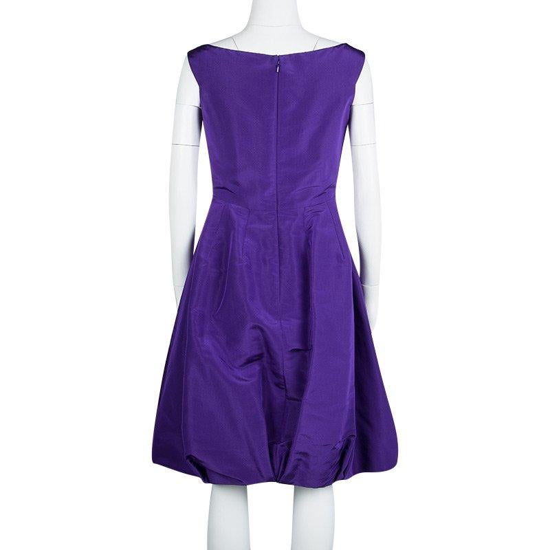 Elegant and classy, this is one dress that every woman dreams of having. Beautifully made from silk, this Oscar De La Renta sleeveless dress has a lovely purple hue, a V neckline and a bow at the front. It also has a calf-length hem which will make