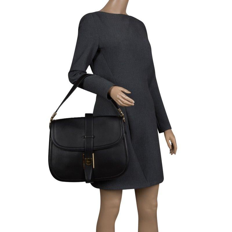 This elegant Elly shoulder bag from Salvatore Ferragamo is comfortable to carry without compromising on style. Crafted in Italy from black leather, the bag features a shoulder strap and foldover top. The interior is suede lined and has a zip