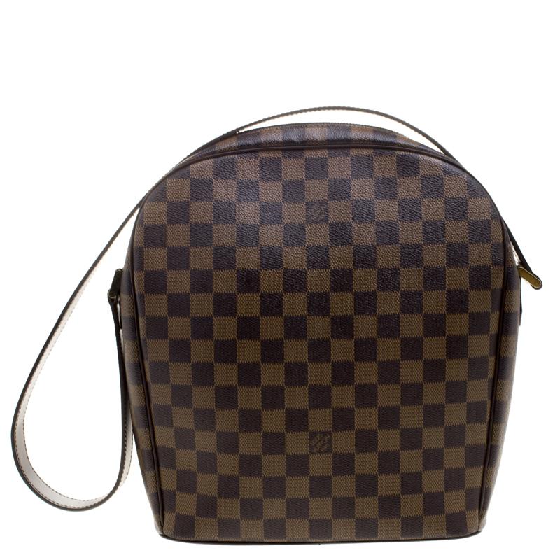 Louis Vuitton's handbags are popular owing to their high style and functionality. Stylish and durable this Ipanema GM bag is a collectible. Crafted from Damier Ebene canvas, the bag comes with a single shoulder strap. The zip closure opens to an