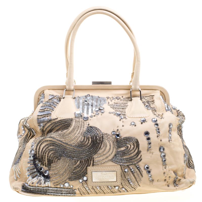 This handbag from Valentino will make the dream of countless women come true. Crafted from leather, this bag has feathers, beads and crystals breathtakingly adorned on the exterior. While the embellishments elevate its beauty, the satin-lined