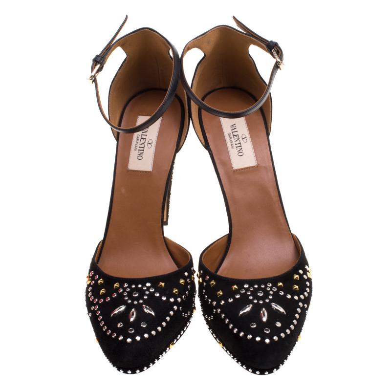 Walk and feel like a diva with these platform pumps from Valentino. They've been decorated with beautiful crystals all over its black suede exterior and designed with closed toes on platforms and a closed back with leather ankle straps. The pumps