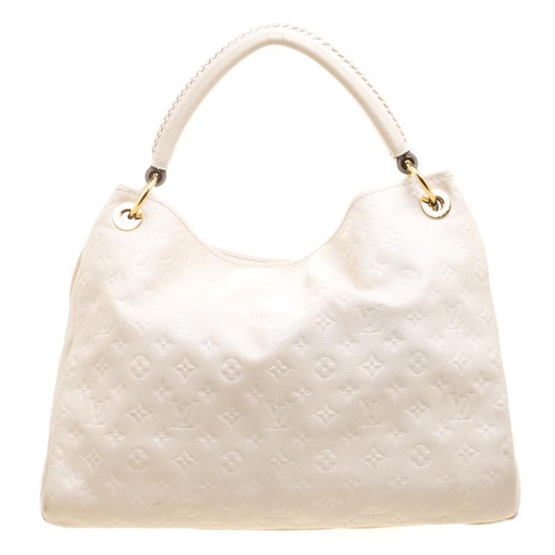 Flaunt this Louis Vuitton Artsy MM bag like a fashionista! Crafted from their signature neige monogram empreinte leather, this bag features an open top that reveals a canvas lined interior, spacious enough to carry all your essentials. The bag is