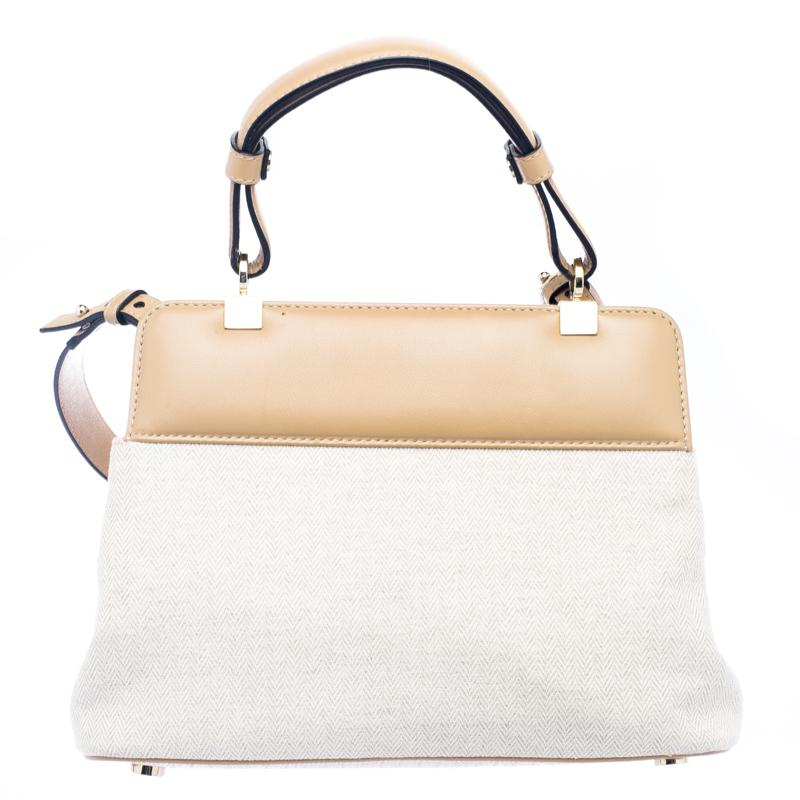 Bvlgari's Isabella Rossellini shoulder bag is a petite yet practical choice for all the young fashionistas out there. It is designed in a beige canvas and leather body with a flap style secured with a turn-lock closure. It comes with a rolled top