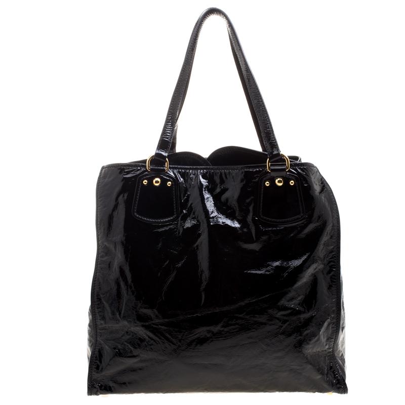 Crafted from patent leather in black, this versatile and practical tote is from Miu Miu. The exterior features a slip pocket on the front, dual top handles and protective metal feet. The bag opens up to a roomy satin lined interior housing a zip