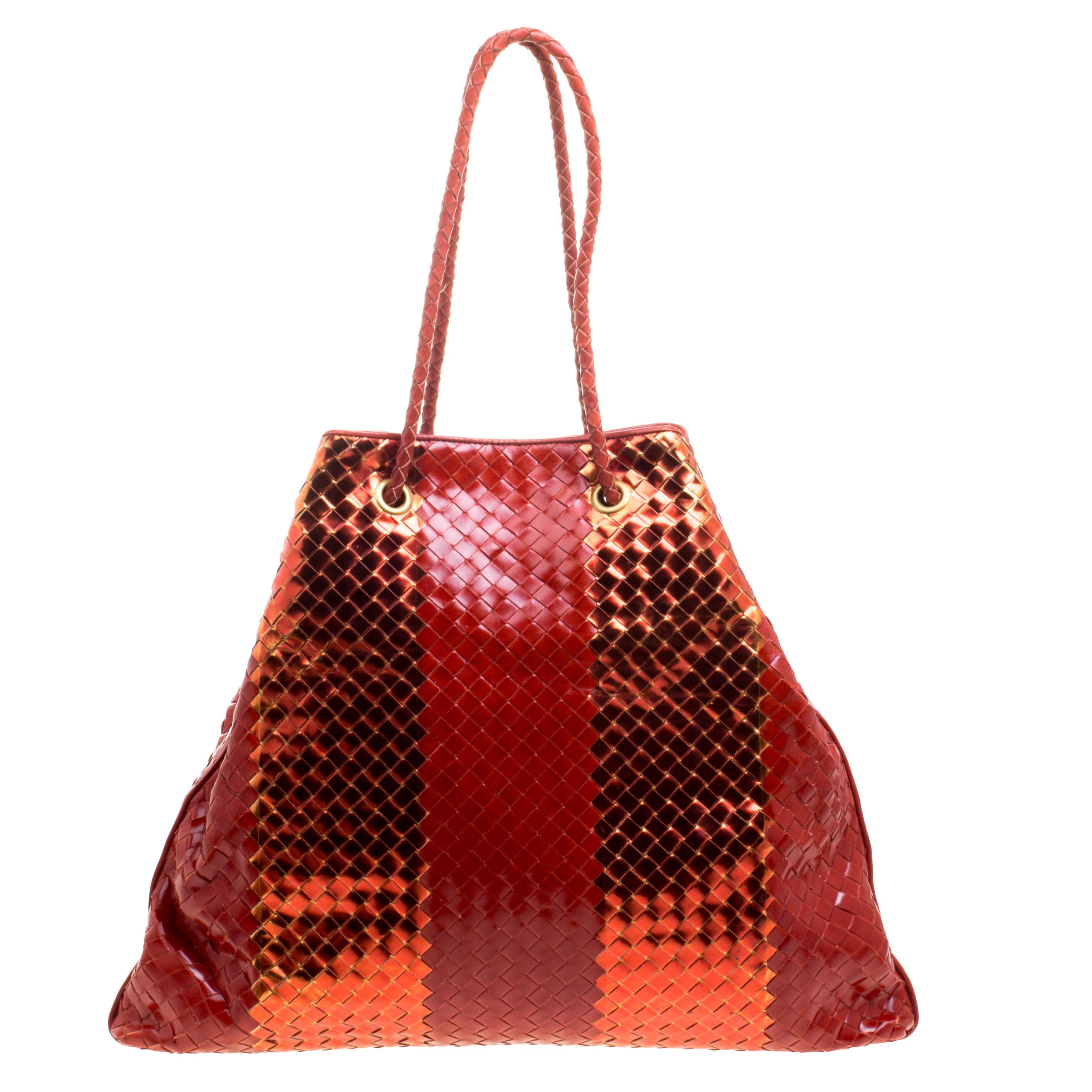This chic tote from Bottega Veneta is crafted from leather. It features dual braided handles and the exterior of the bag beautifully flaunts the famous Intrecciato pattern that is unique to the fashion house. It has a roomy suede lined interior that