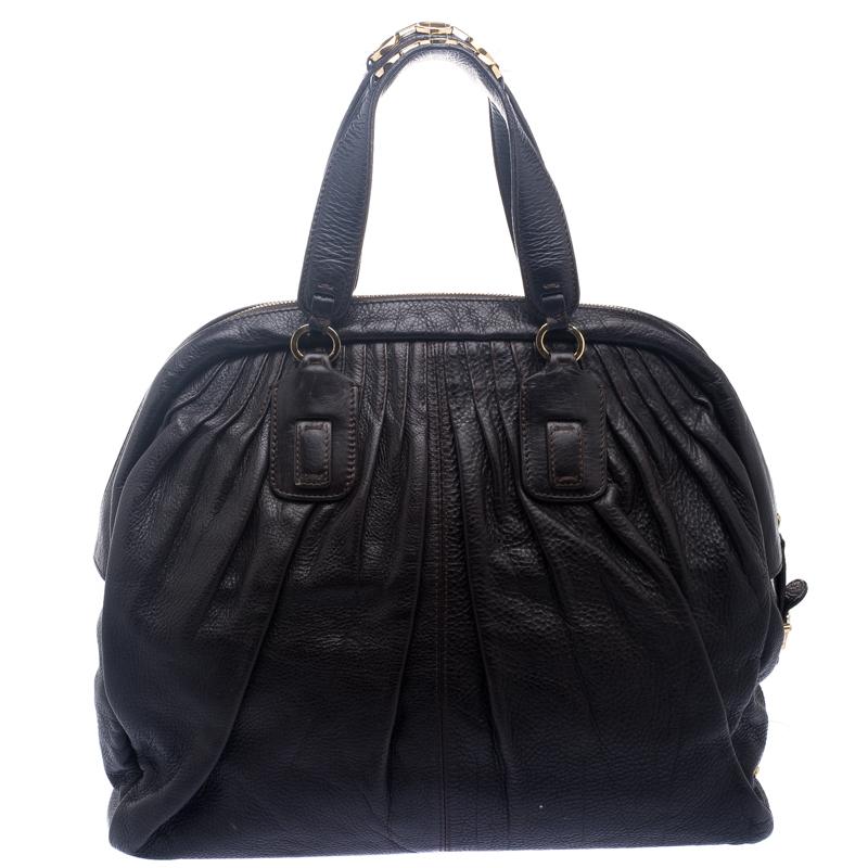 This bag from Roberto Cavalli exudes class and luxury. Crafted from pleated leather, the bag features dual handles and protective metal feet at the bottom. The zip top closure opens to a nylon lined interior that houses a zip pocket and a cell phone