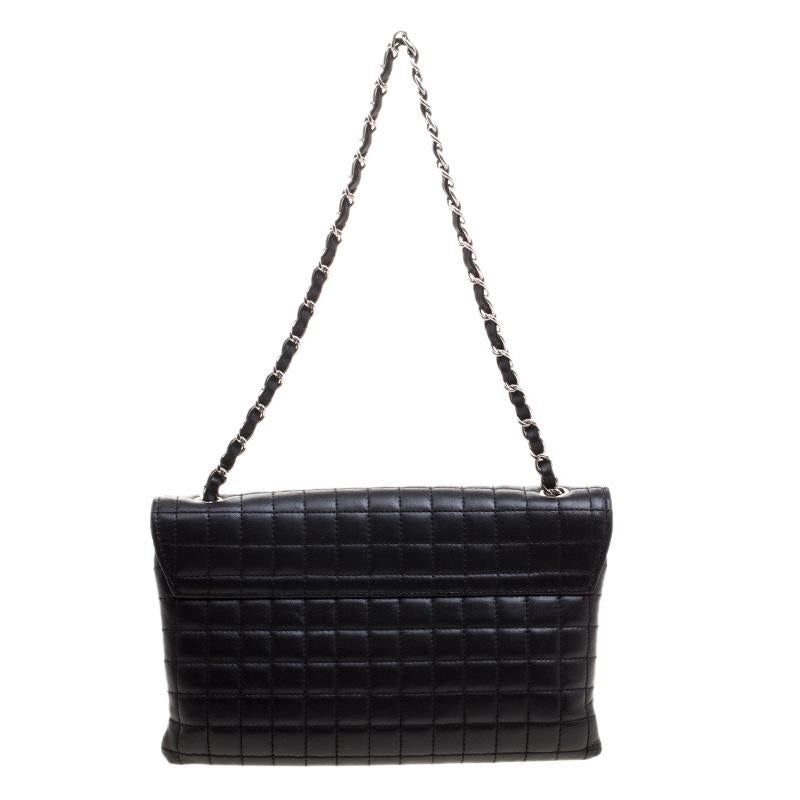 This Chanel black shoulder bag is simply gorgeous! It has been beautifully crafted from leather and designed in their signature square quilt with details like 5, the CC logo and a Camellia applique on the flap. The bag also hosts a well-sized fabric