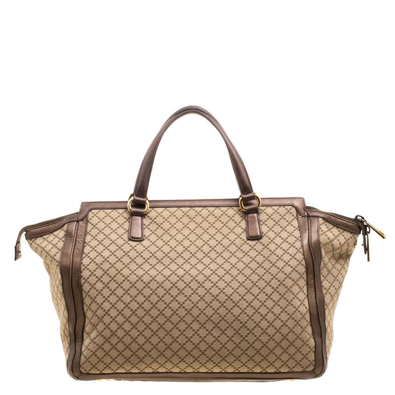 High in style and craftsmanship, this 1973 top handle bag from the house of Gucci has been crafted from canvas and leather. The canvas lined interior houses slip pockets and a zip pocket. The bag is equipped with dual handles and protective metal