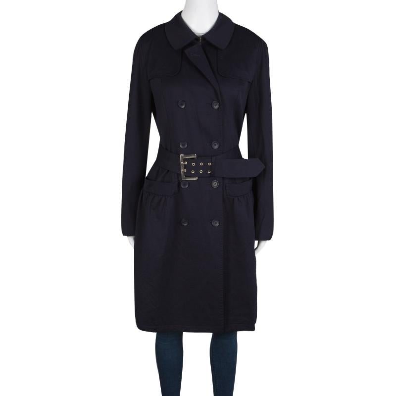 Layer up in style with the Max Mara Studio Navy Blue Jersey Belted Double Breasted Trench Coat. The coat comes in a tapered silhouette that flaunts the look with a buckled belt at the waist to accentuate the shape. The front of the coat is lined