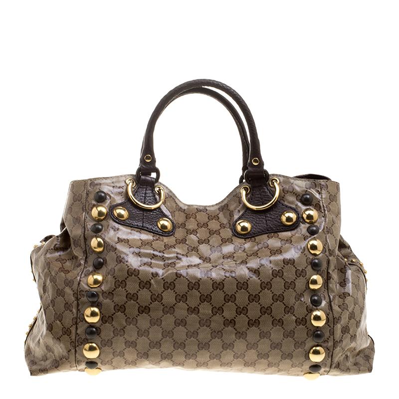 This chic Gucci Babouska bag might just become the most-loved tote in your closet. Crafted from GG crystal canvas, it is decorated with suede fringes, gold-tone stud detailing and the heart emblem on the front. The bag is equipped with two leather