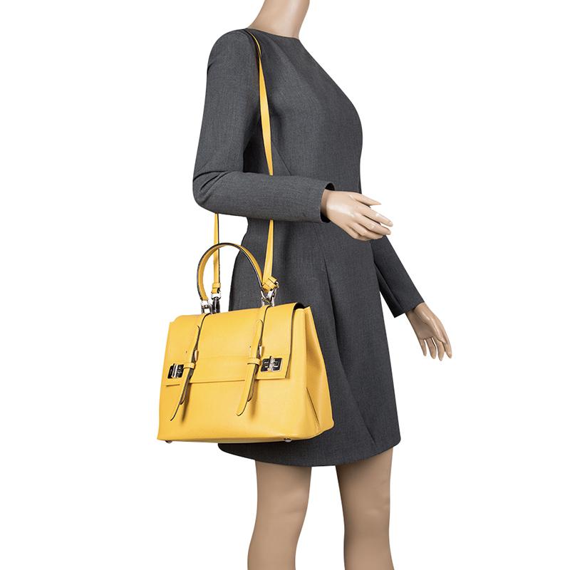 This stylish satchel from Prada has a structured look. The bag is crafted from Saffiano Cuir leather and features buckle detailing on the flap. The interior is leather lined and spacious enough to hold your everyday essentials. The stahcel is