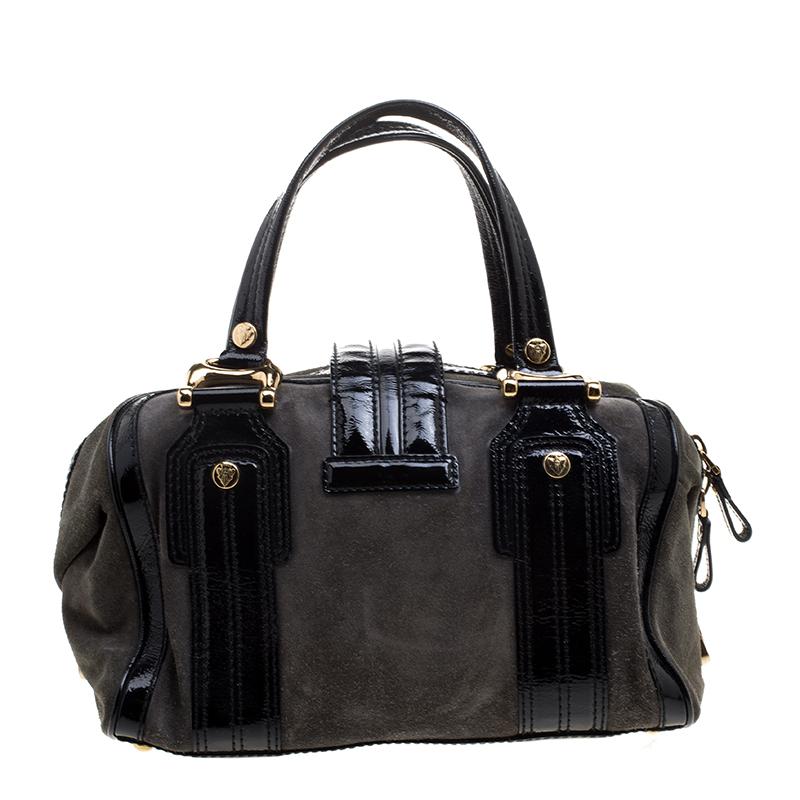 A truly posh and elegant piece to add to your collection. This Boston bag by Gucci is crafted from patent leather and suede, and it is styled with a flap that carries an emblem for a lock. It also has a top zip closure, two handles, protective metal