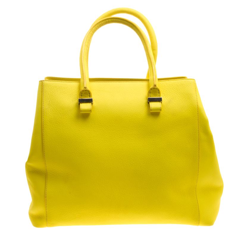 This poppy yellow Quincy tote from Victoria Beckham is sure to make heads turn. Expertly crafted with leather, the creation features a sufficiently sized fabric interior equipped with a zip pocket and slip pockets. Swing it with ease by using the