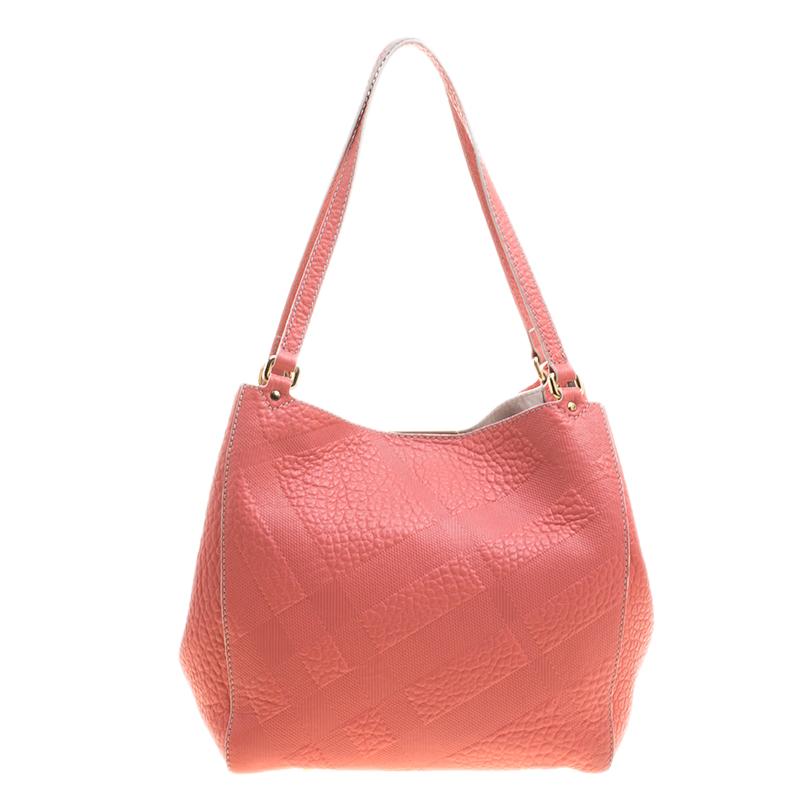 This Canterbury tote from Burberry is crafted from embossed leather and fabric and features a pink hue. It comes with dual flat handles, protective metal feet and a leather lined interior that can hold all your daily necessities. Simple in design,