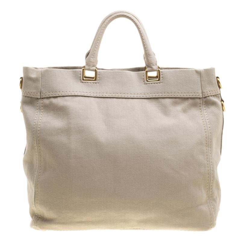 When you carry this Prada creation, be ready to catch admiring glances as this tote is stylish and handy. The bag has been crafted from denim in a gorgeous beige hue and equipped with two top handles, a very spacious nylon interior and the brand