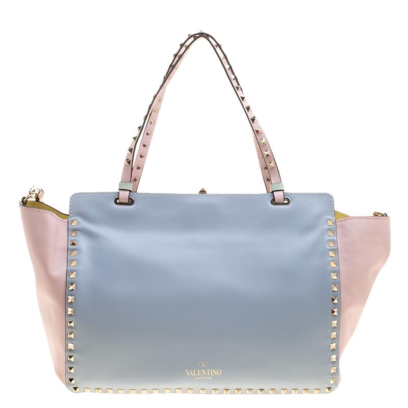 Valentino brings you this super-stylish tote that carries a design which will surely grab the attention of your onlookers. It has a fabulous tricolour exterior and the signature pyramid studs decorated on the exterior and on the two top handles and