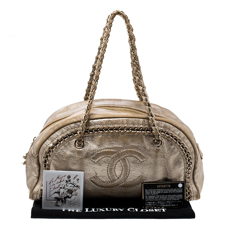 Shimmer with elegance when you swing this Boston bag from Chanel. Beautifully crafted from leather in metallic gold, and designed with chain trims and the CC logo on the front, this Boston is a beauty. A zip closure secures a spacious leather