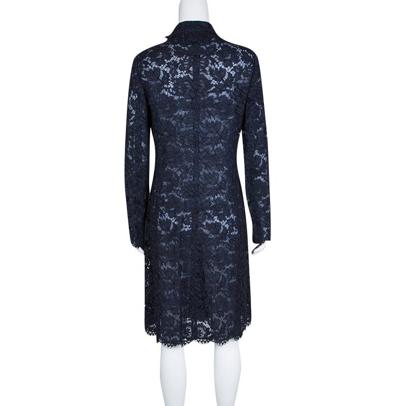 Valentino gives just the right dress to make a high-end fashion statement. This navy blue piece is made of cotton blend adorned with decorative lacework. Lined with silk, this double-breasted dress is embellished with front buttons and is designed