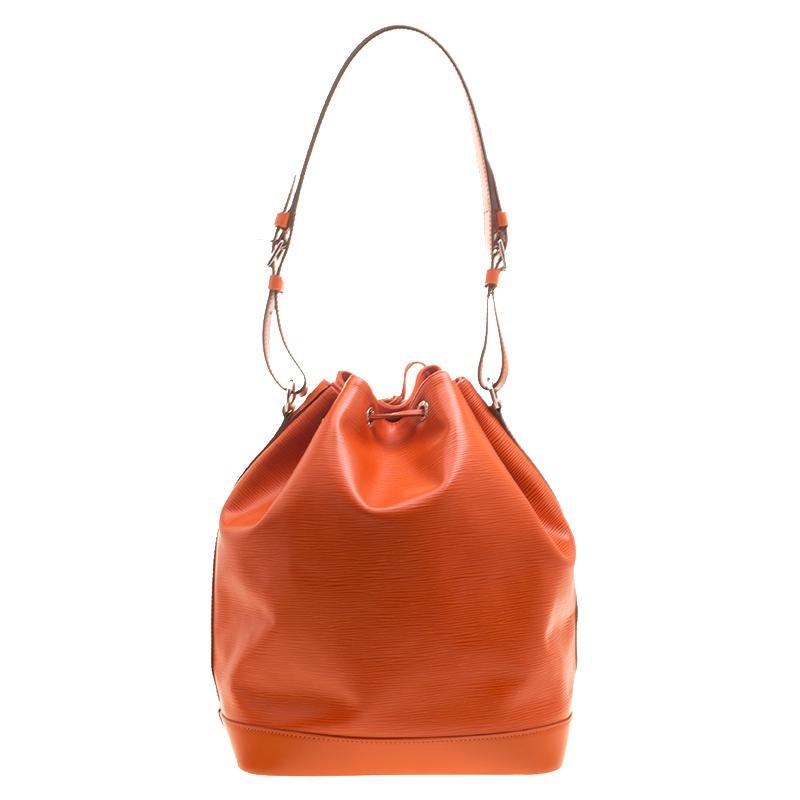 Made from Epi leather, this Noe bag by Louis Vuitton exudes just the right amount of sophistication. The orange bag has a single adjustable strap with silver-tone buckles, a drawstring fastening and an Alcantara lined spacious interior. This piece