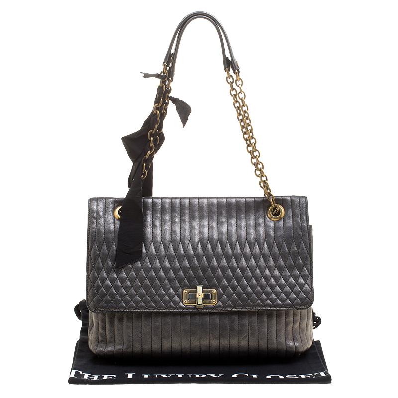 Crafted to excellence, this Happy shoulder bag from Lanvin is crafted with metallic grey quilted leather. The twist lock unfastens the flap that reveals a spacious interior lined with monogram fabric. This beauty is held by dual chain link shoulder