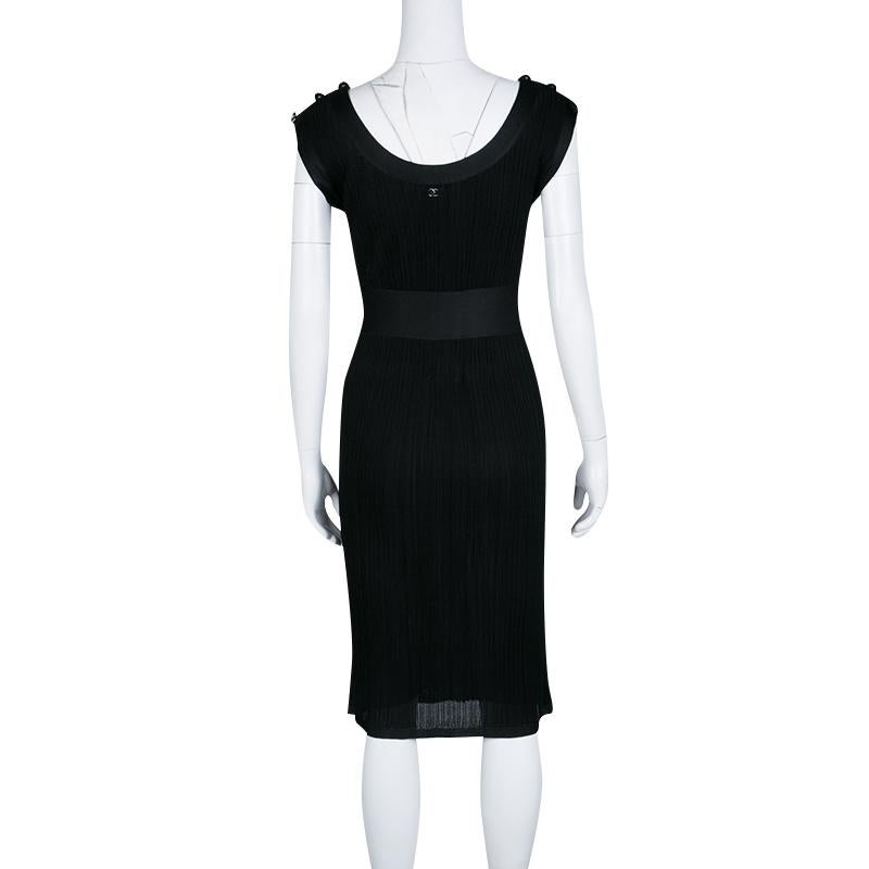 It is a classic black dress from Chanel that is cut to a slim silhouette. Ideal for parties and gatherings, the dress has a textured finish. It has fitted silk waistline and button details on the shoulders. This sleeveless dress will make you stand