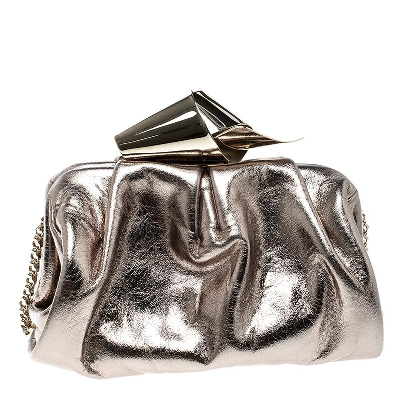 This Cara clutch will add oodles of charm and elegance to your party looks. This splendid Jimmy Choo creation comes crafted in gold leather and exudes a gleaming metallic finish. A lovely knot detail sitting on the top of the bag lends the piece a