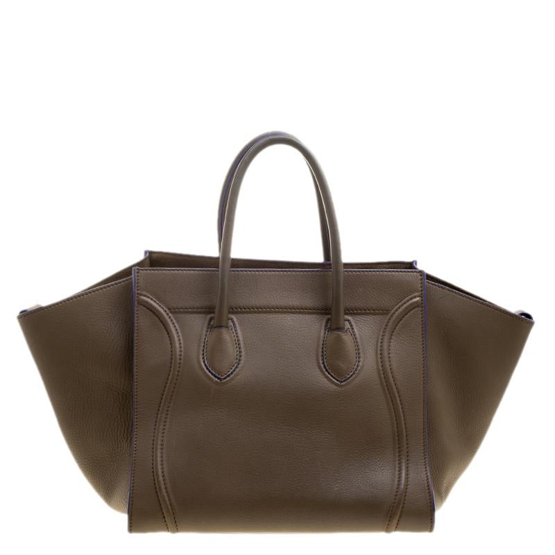 This Celine medium Phantom Luggage tote is perfect for everyday use. Crafted from leather, the bag features signature flappy wings, double rolled handles, a front zip pocket and protective metal feet at the bottom. The bag opens to a roomy leather