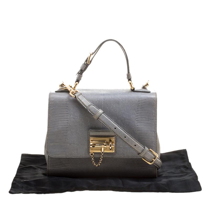 Crafted from a luxurious grey iguana-embossed leather, this Monica satchel features a sleek design perfectly sized to hold essentials- think of cell phone, cards and keys. The flap style comes with a gold-tone lock and an animal print interior.