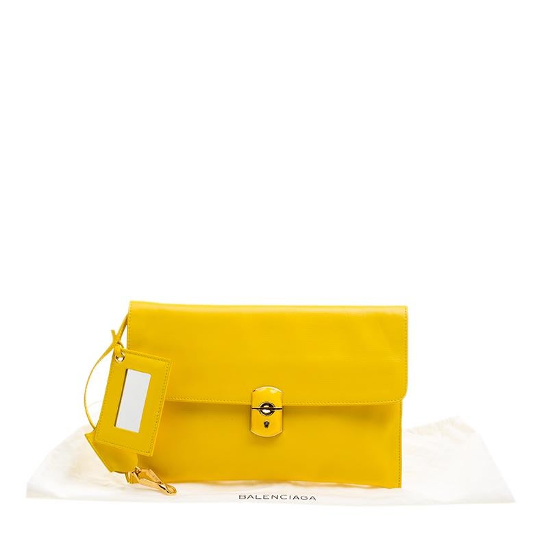 This Balenciaga clutch simply floors us with its beauty. Wonderfully crafted from curry leather, this clutch comes designed with a canvas interior housing a zip pocket and a push lock on the flap. Accompanied by a compact mirror and a clochette,