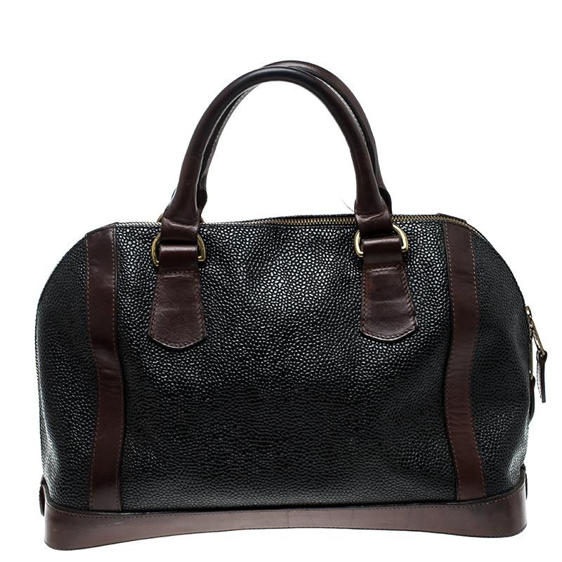 Super functional and modish, this Mulberry Vintage satchel is a serious style elevator. It is crafted with black Scotchgrain leather featuring brown leather trims on the front and the bottom. It comes with a spacious interior lined with fabric, and