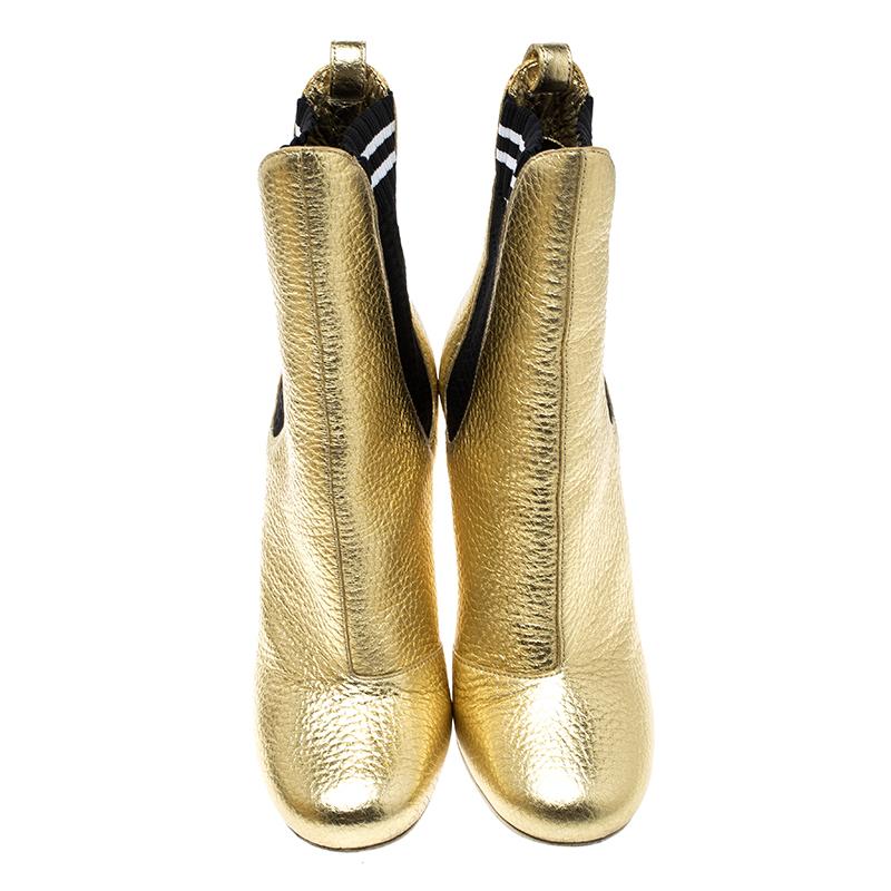 Crafted to perfection out of crackled metallic gold leather, these boots feature a tall heel and panels of jet black stretch fabric that make these ankle boots easy to take on and off. Modern and versatile, these shoes can be taken from day to night