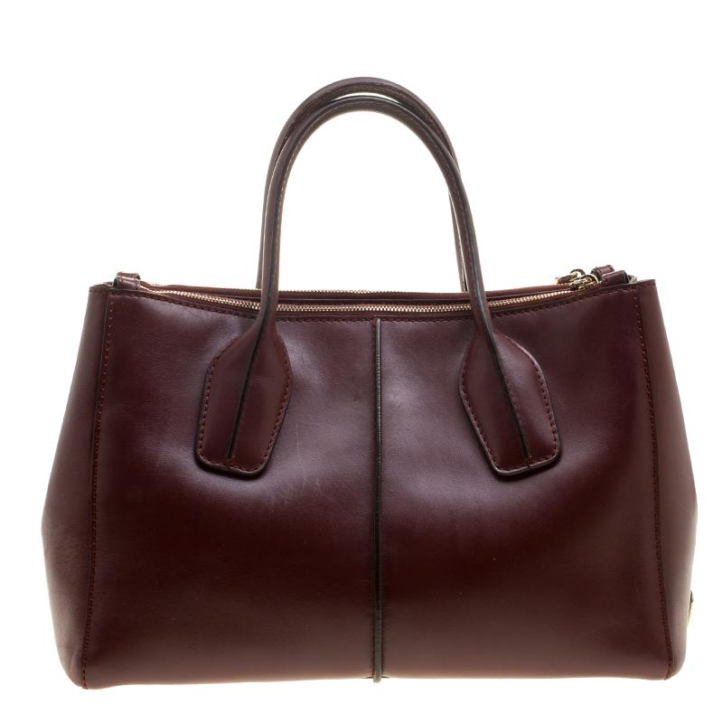 Designed in sleek and elegant style that can work with both professional and casual chic looks, this Tod’s D-Styling shopper tote is effortlessly stylish and extremely practical. Crafted in burgundy leather, this bag is accented with gold tone