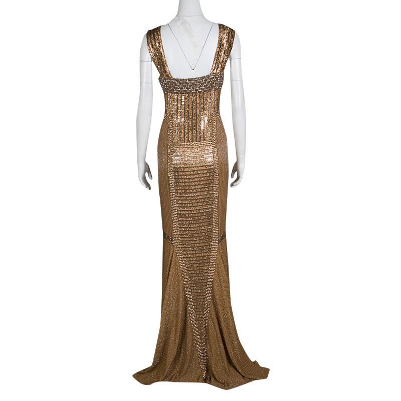 Recreating the glitz and glamor of the 90s, this evening gown from Gianfranco Ferre is sumptuously embellished with sequins, stones, and beads. Cut from dull golden silk in a sleeveless design, it is an apt choice for black-tie events and cocktail