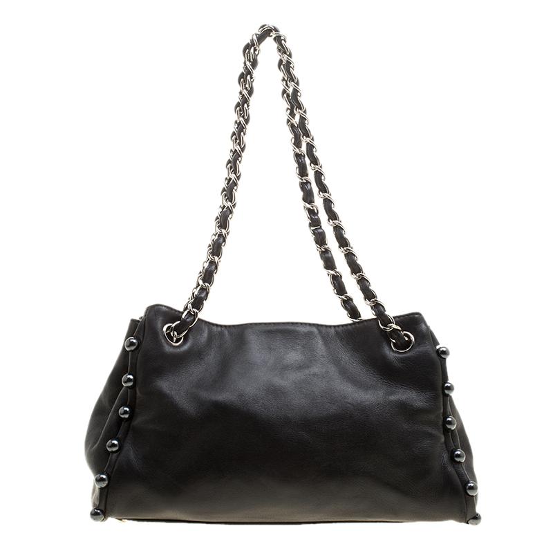 This Obsession tote from Chanel will be your new favorite accessory to complement with those elegant outfits of yours. It is rendered in leather featuring notable CC logo inlaid with pearls on the front. It is styled with pearl embellished borders