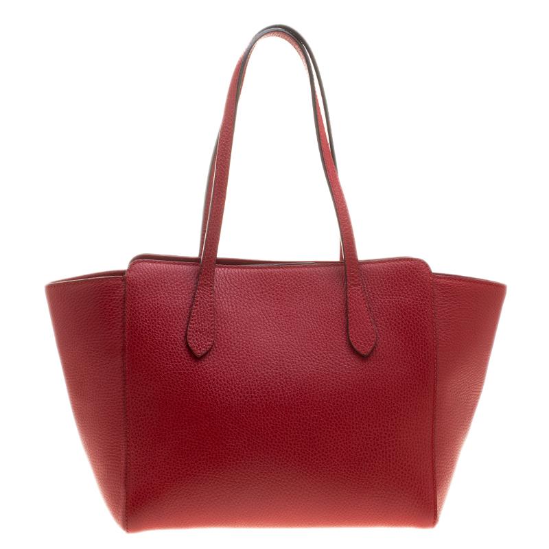 Carefully designed to create a plush and chic impression, this red leather bag is sure to make heads turn. Created with canvas lining and held by two handles, it can handle all your essentials. Coming from Gucci, this will showcase your
