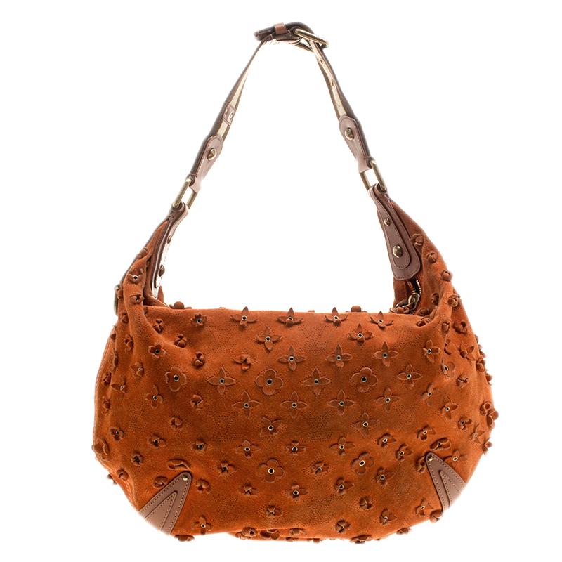 A limited edition piece, this Onatah Fleurs GM hobo by Louis Vuitton is a marvelous bag with a distinctive structure and unique details. Crafted with brown suede, the exterior of the bag is delicately perforated with LV monogram and is further