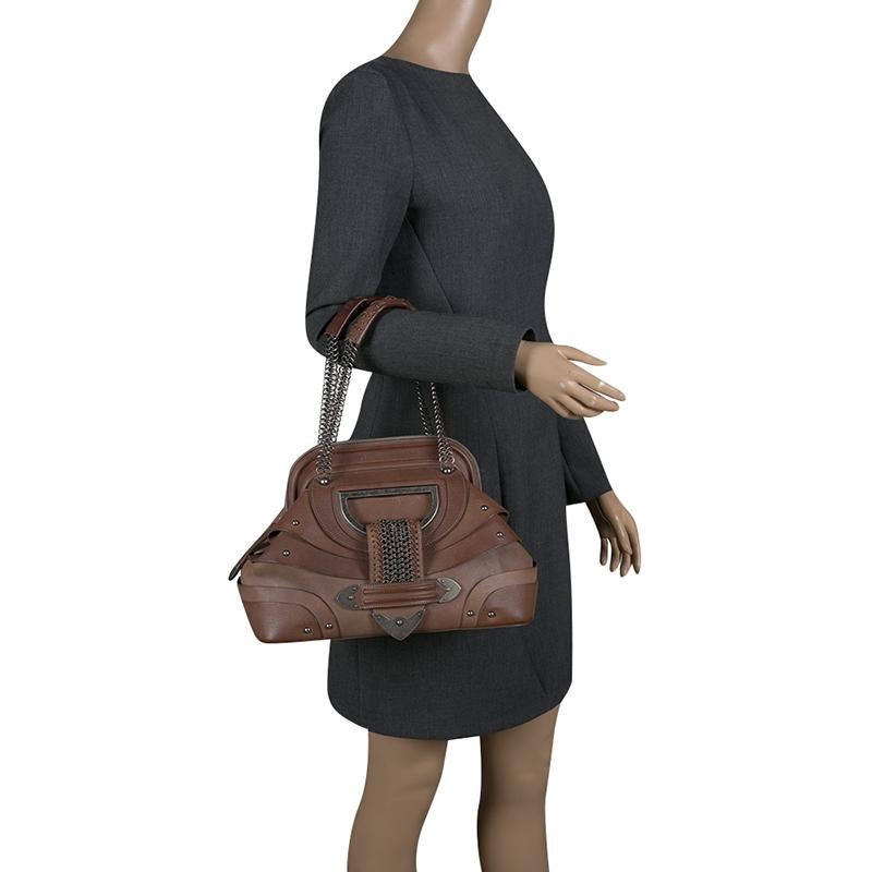 This Dior creation epitomizes wonder and ladylike style. Flaunt this graceful, brown leather bag with your getup for an attractive look. It has a tuck-in flap detail, two chain handles with leather rests, and a well-sized nylon