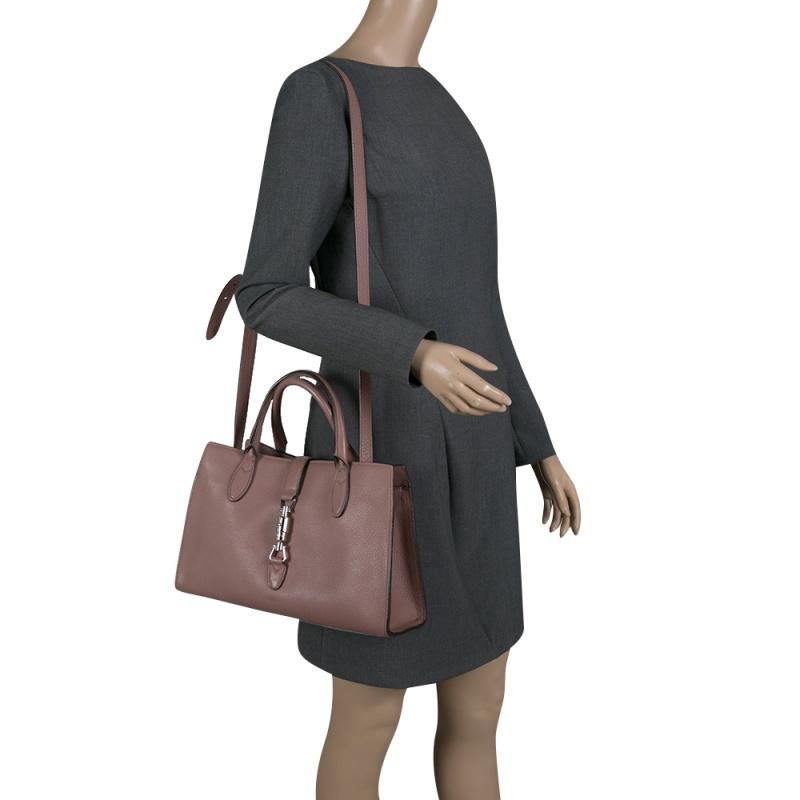 Gucci showcases a masterfully designed leather tote to assist you with style. The inside is lined with suede and sized for your ease. Impressive and fashionable, style your outfit with this dusty pink piece and carry it with the two handles or