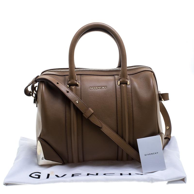 This exquisite Givenchy Lucrezia Duffle bag is a classy closet addition. Crafted in brown leather, its exterior features a structured leather trims, double top handles and an adjustable shoulder strap. The bottom comes with protective metal feet