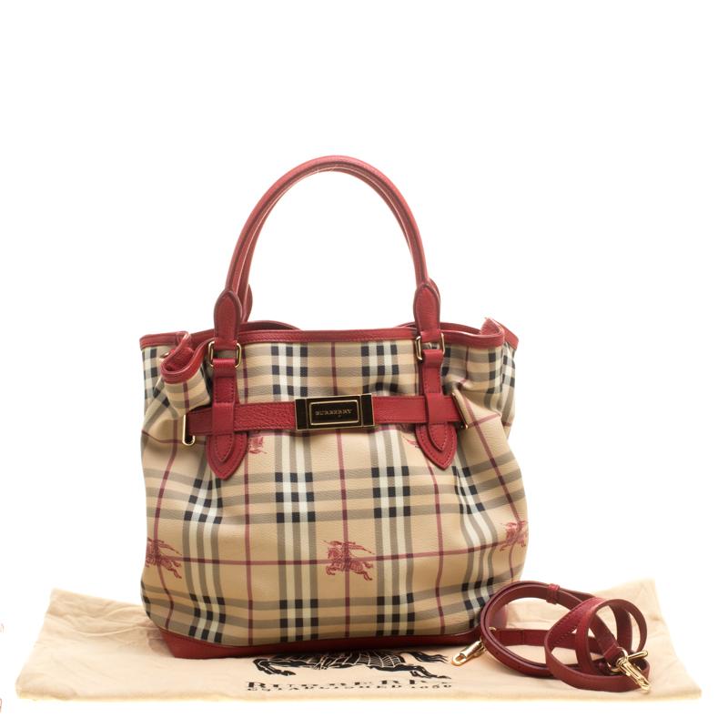 The perfect companion for your everyday looks, this Medium Golderton tote from Burberry is styled in signature Haymarket check PVC with red-coloured leather trims. The exterior of this lovely bag features a leather belt detail complete with