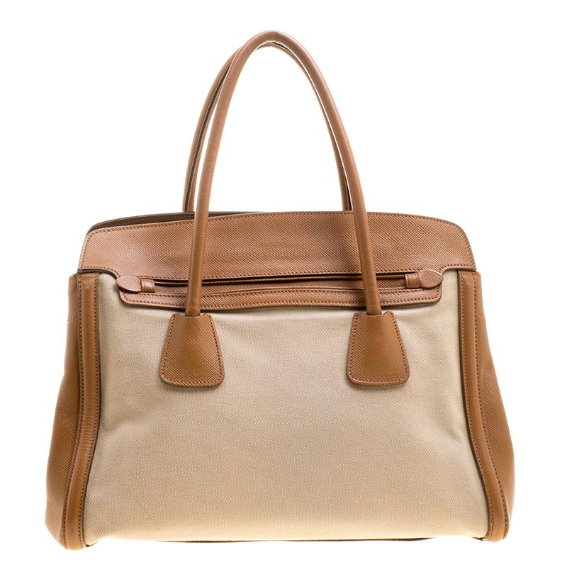 Stunning in appeal and high on style, this tote by Prada will be a valuable addition to your closet. It has been crafted from Corda canvas and Saffiano leather in two lovely shades. It comes with two top handles, protective metal feet and a spacious