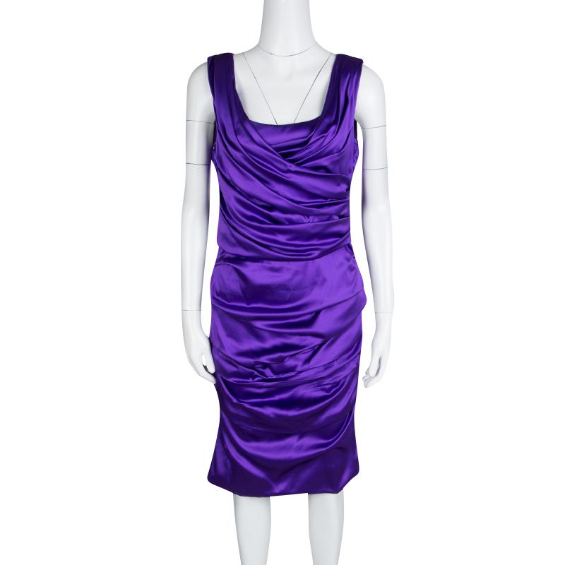 There's an elegant, sculptural quality to Dolce and Gabbana purple sleeveless satin dress designed with a layered ruched pattern across giving it an extra impact. It has a beautiful ruched design on the front and back with full shining fabric to