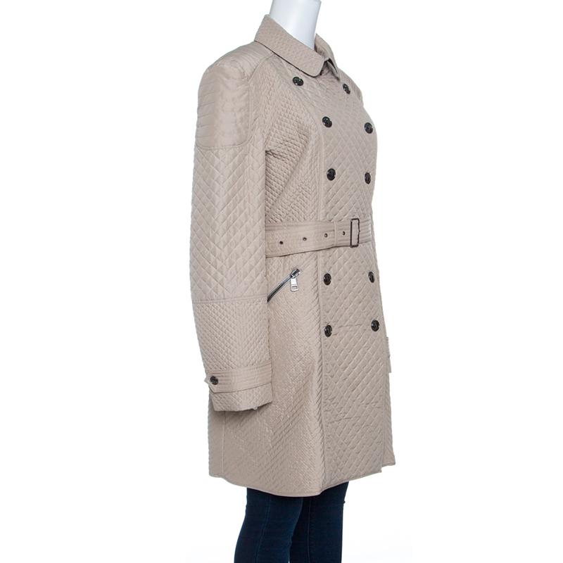 Burberry London brings forth its classic trench coat in a chic new look. Featuring a stylish diamond quilted surface, this beige coloured trench coat has a belted waist that makes sure you can securely pair it over your dress and tops for a smart