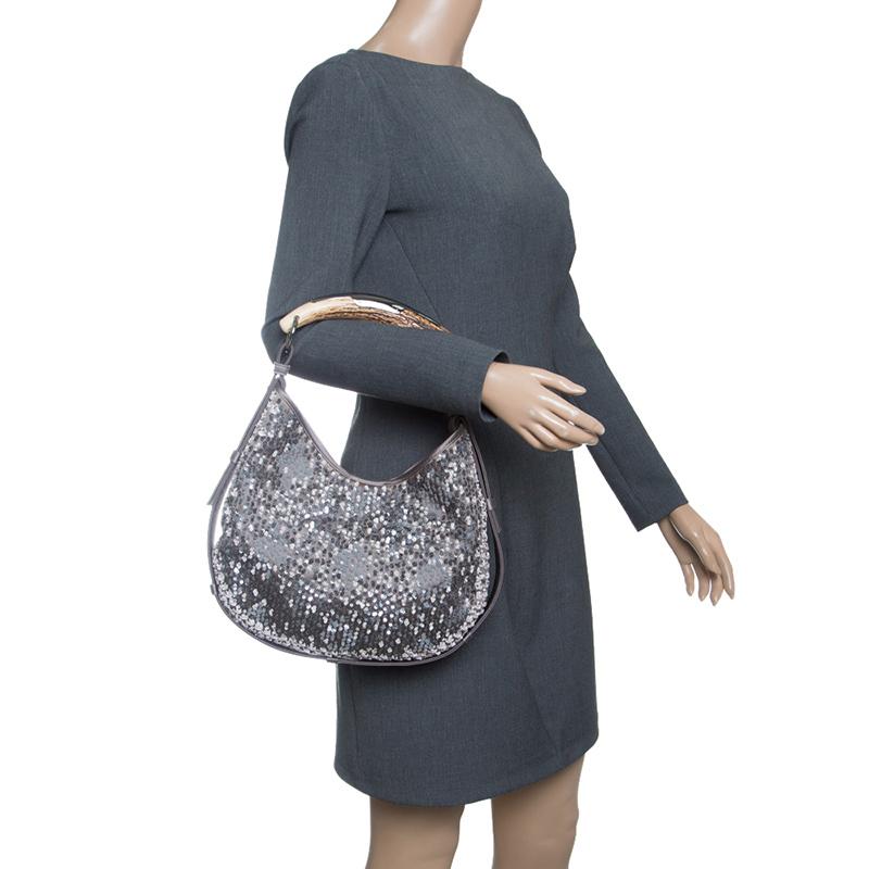 Saint Laurent Paris has infused interesting, unique details in this notable Mombasa shoulder bag. It is beautifully made with satin and decorated with sequins all over with protective leather trim outlining the bag. A signature of the Mombasa style,
