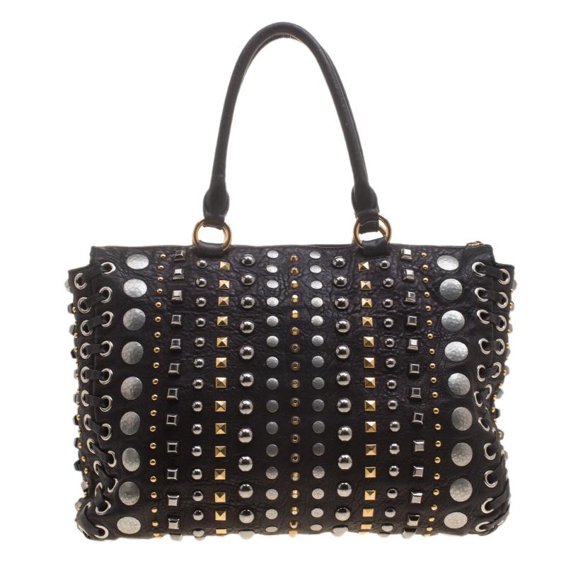 This Monk bag from Miu Miu will make one splendid addition to your bag collection. It is crafted from leather and designed with studs of various shapes. The bag has two handles and a top zipper to secure the spacious satin interior.

Includes: The