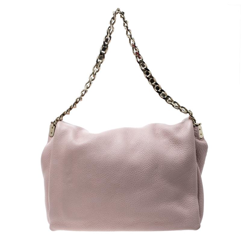 This impressive shoulder bag in a lovely blush pink colour can be carried with multiple outfits. This piece by Valentino is crafted from leather and designed with a pyramid stud on the flap and a shoulder chain. Lined with suede, it will keep your