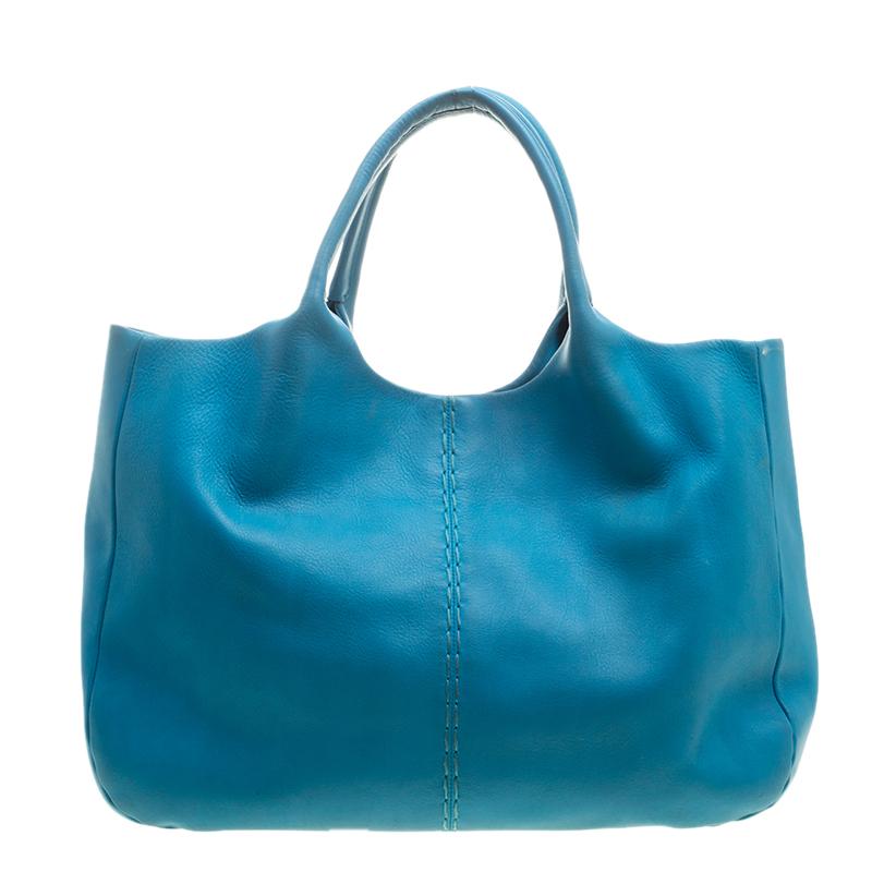 Tod's shoulder bag, crafted with blue leather is stylish and functional. The bag comes with dual top handles and the brand logo on the front. It features a snap button closure that reveals a satin lined interior housing a zip pocket. Carry this