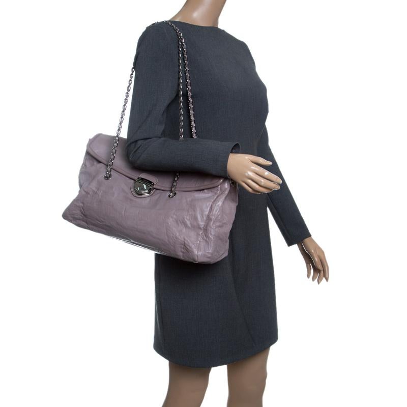 Complement your chic outfits with this elegant satchel from Prada. It is accented with an appealing chain-link sling strap interwoven with leather for prompt usage. Its roomy interior is finished with a flap top secured with push lock closure and