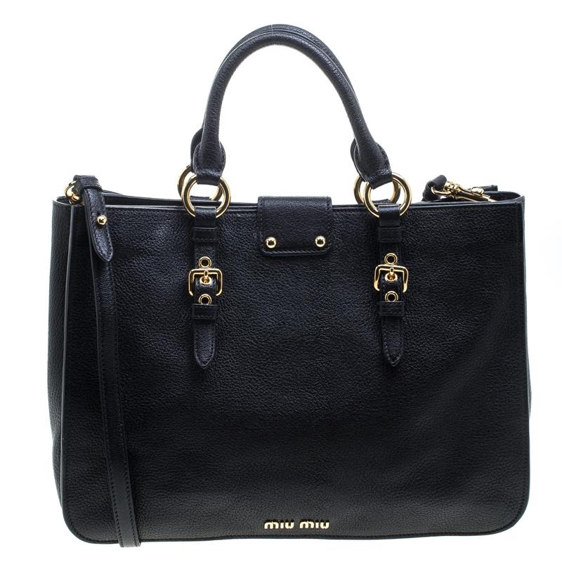 This Madras Executive tote by Miu Miu combines luxury and utility. It is crafted from black leather with a front Miu Miu push-lock closure, rolled leather handles, a detachable and adjustable shoulder strap and gold-tone hardware detailing. The